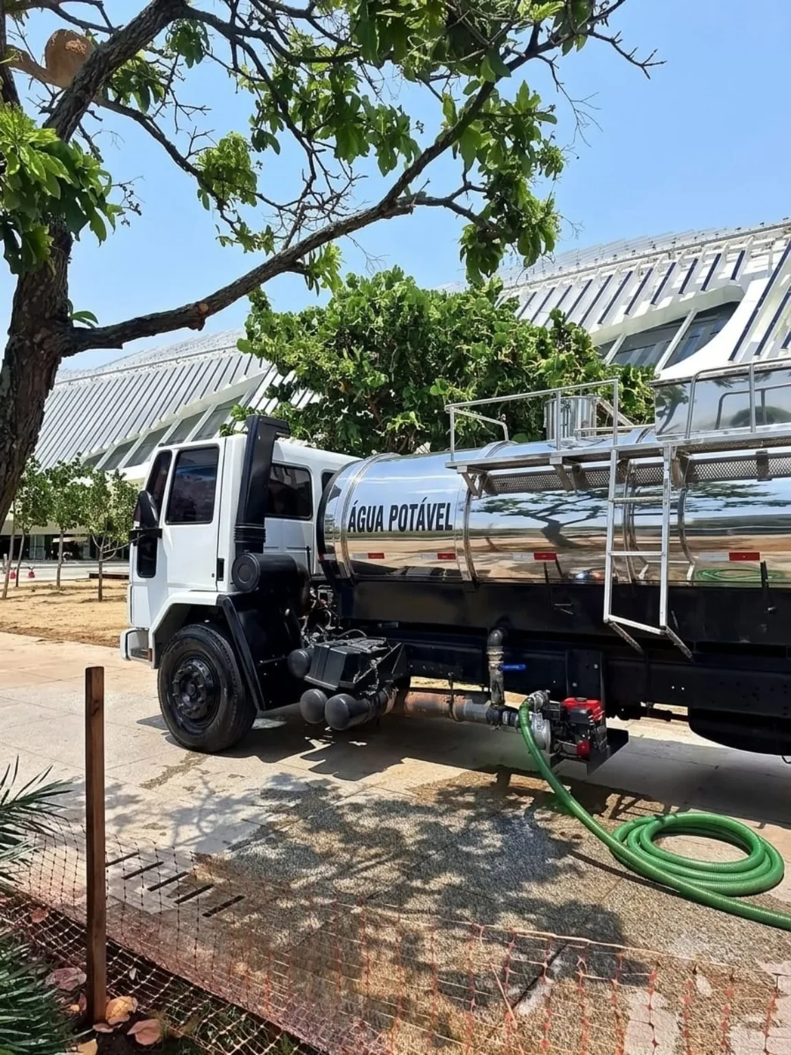 Caminhão-pipa DJRA em atendimento com tanque de inox e mangueira de abastecimento